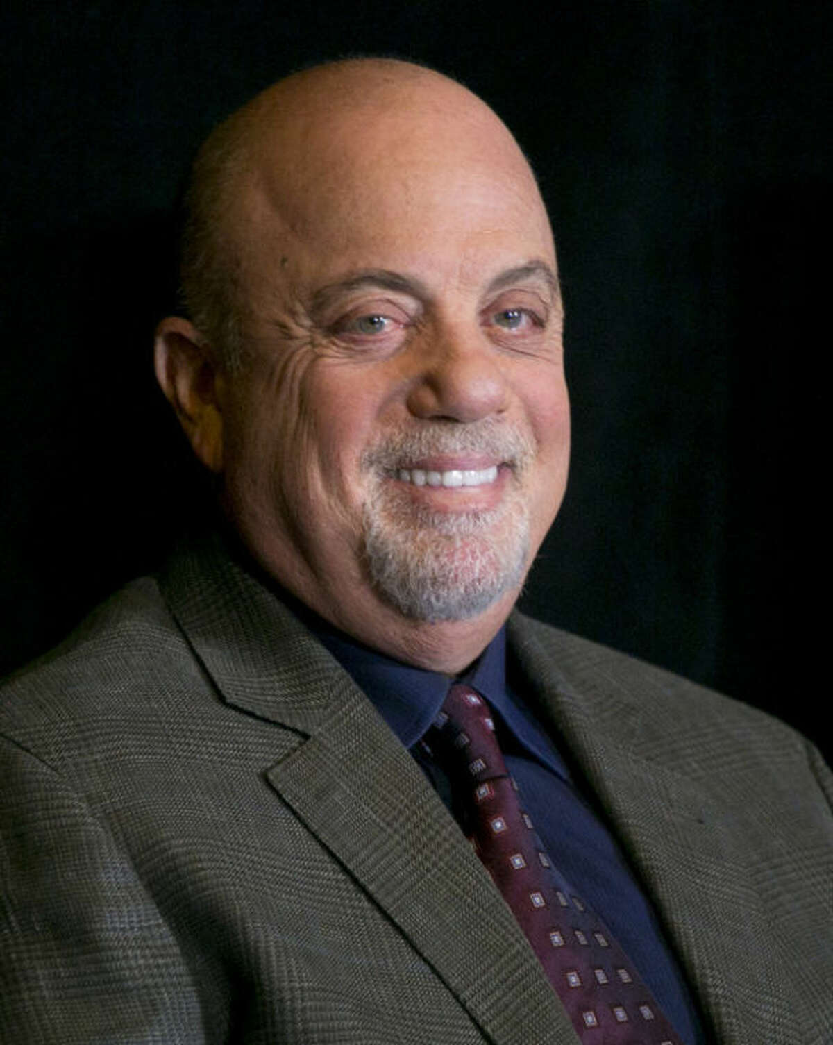 Billy Joel smiles at a news conference at Madison Square Garden, Tuesday, Dec. 3, 2013 in New York. The icon announced he will perform a residency at the famed NYC venue once a month for as many months as New Yorkers demand. He is set to perform sold out shows on Jan. 27, Feb. 3, March 21 and April 28. He will also perform on his 65th birthday, which is May 9. (AP Photo/Mark Lennihan)