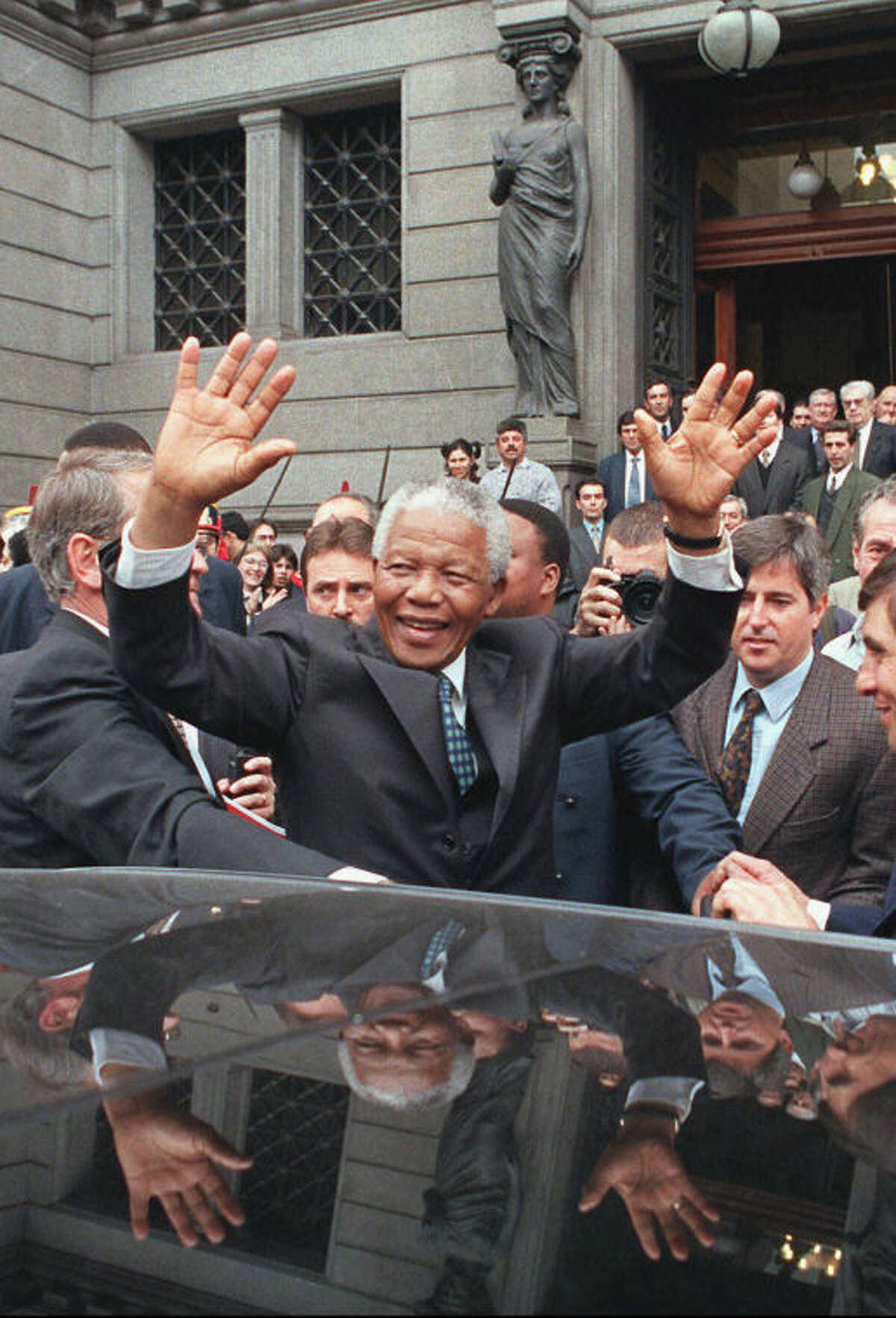 FILE - In this July 23, 1998 file photo, South African President Nelson Mandela greets a crowd outside the National Congress building in Buenos Aires, Argentina, as he arrives for a meeting of the four-nation South American Common Market, or Mercosur. South Africa's president Jacob Zuma says, Thursday, Dec. 5, 2013, that Mandela has died. He was 95. (AP Photo/Daniel Muzio, File)