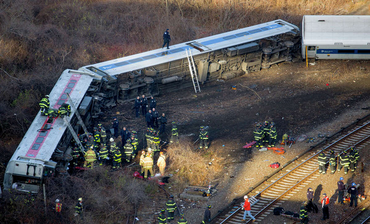 First responders gather at the derailment of a Metro-North passenger train in the Bronx borough of New York Sunday, Dec. 1, 2013. derailed on a curved section of track in the Bronx on Sunday morning, coming to rest just inches from the water and causing multiple fatalities and dozens of injuries, authorities said. Metropolitan Transportation Authority police say the train derailed near the Spuyten Duyvil station. (AP Photo/Craig Ruttle)