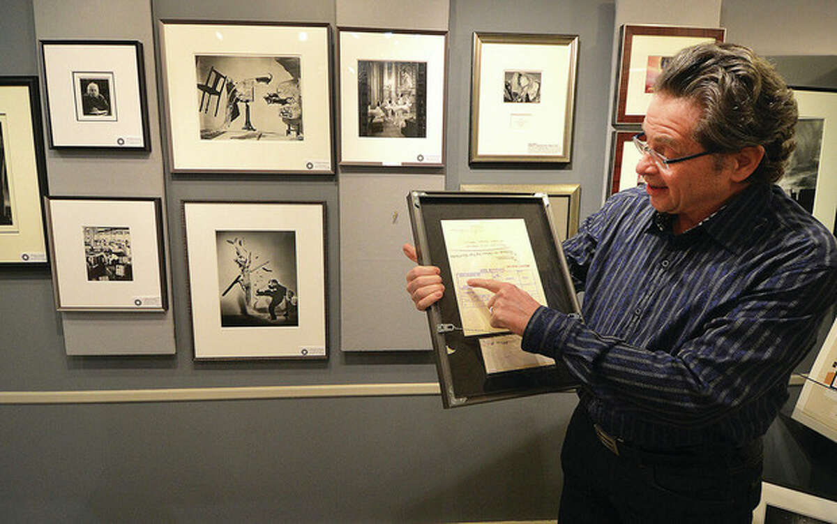 Hour Photo / Alex von Kleydorff Artist's Market owner Jeffry Price looks over the photographer Alfred Eisenstaedt's notes on the back of a photo he took of Grand Central Terminal for Life Magazine in 1961. The image along with others were used as teaching tools for lessons at the famous Photographers School that was in Westport.