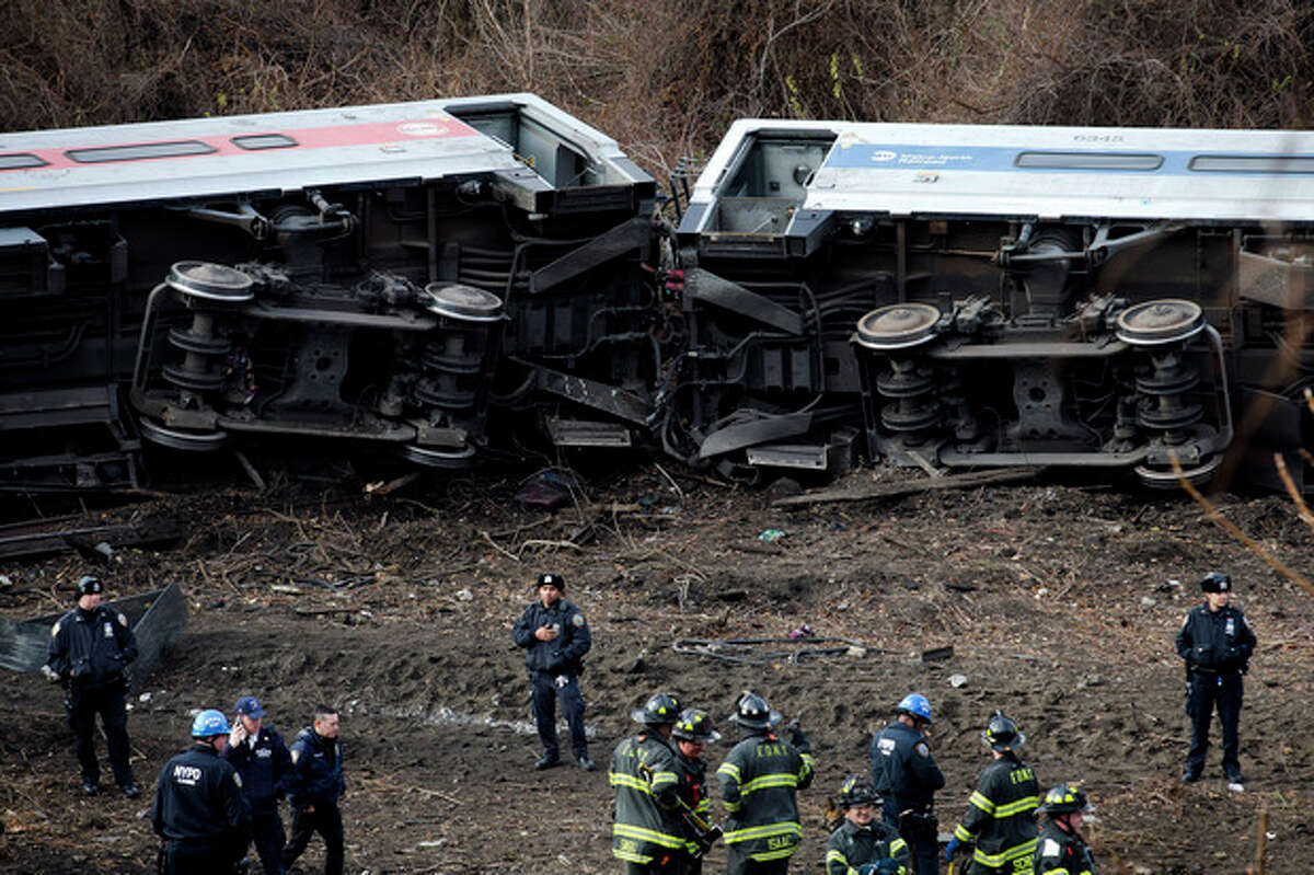 Emergency personnel respond to the scene of a Metro-North passenger train derailment in the Bronx borough of New York Sunday, Dec. 1, 2013. The train derailed on a curved section of track in the Bronx on Sunday morning, coming to rest just inches from the water and causing multiple fatalities and dozens of injuries, authorities said. Metropolitan Transportation Authority police say the train derailed near the Spuyten Duyvil station. (AP Photo/Craig Ruttle)