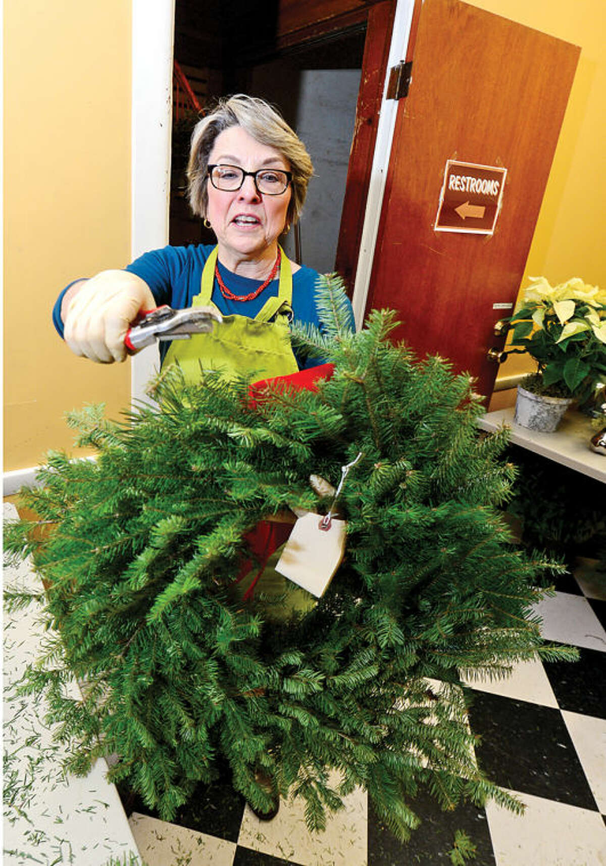 Hour photo / Erik Trautmann Rowayton Gardeners Club members including Nancy Schlater create one-of-a-kind wreaths, boxwoods trees and festive table arrangements for their annual christmas fair this Saturday.