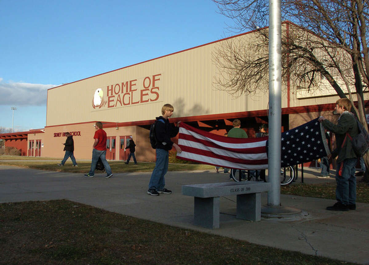 Sidney High School students fold the American flag at the end of a school day in Sidney, Mont., in this photo made Nov. 5, 2013. Almost two years after the murder of a long-time math teacher at the school, 43-year-old Sherry Arnold, attorneys for defendant Michael Keith Spell are seeking to have him declared unfit for trial due to mental disability. (AP Photo/Matthew Brown)