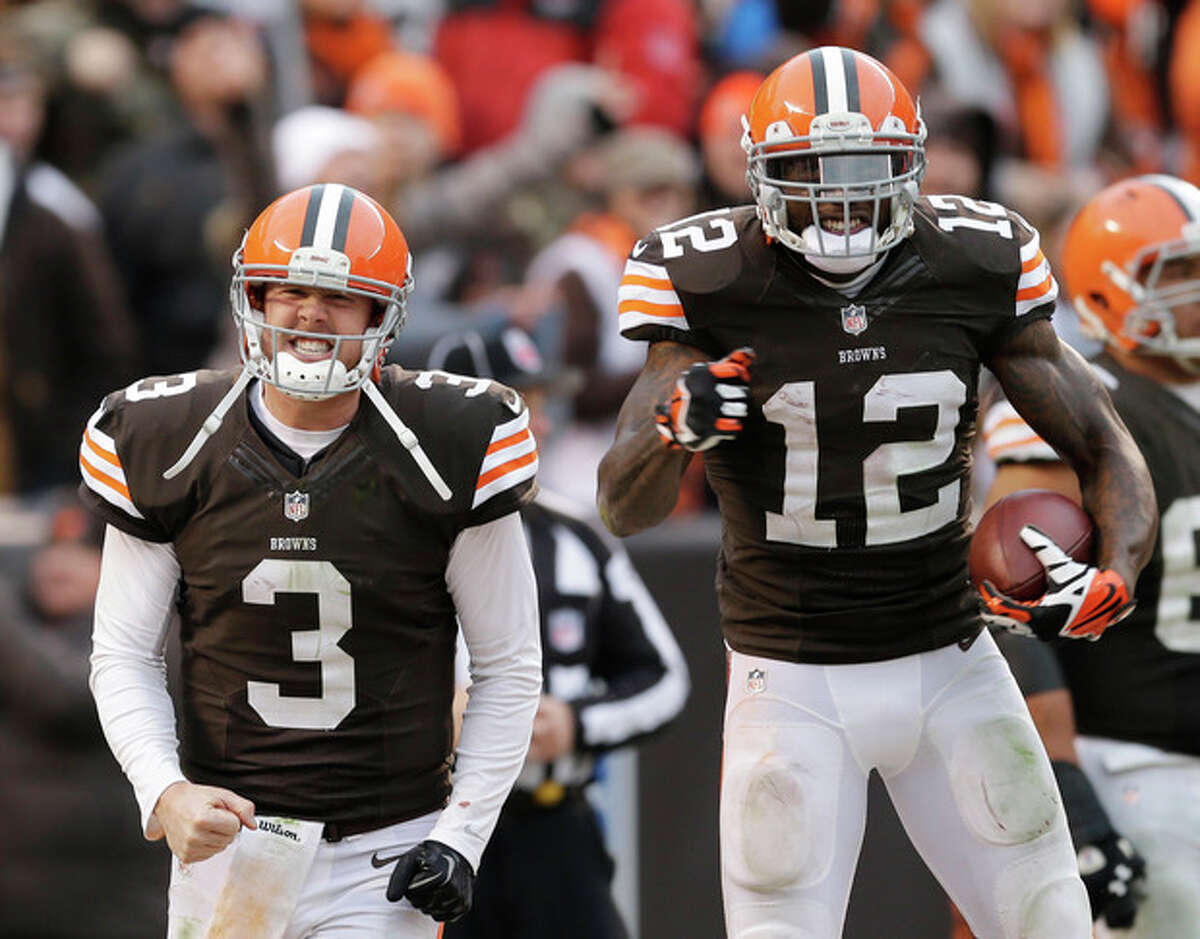Cleveland Browns quarterback Brandon Weeden (3) celebrates with wide receiver Josh Gordon (12) after they connected on a 95-yard touchdown pass in the fourth quarter of an NFL football game against the Jacksonville Jaguars, Sunday, Dec. 1, 2013, in Cleveland. (AP Photo/Tony Dejak)