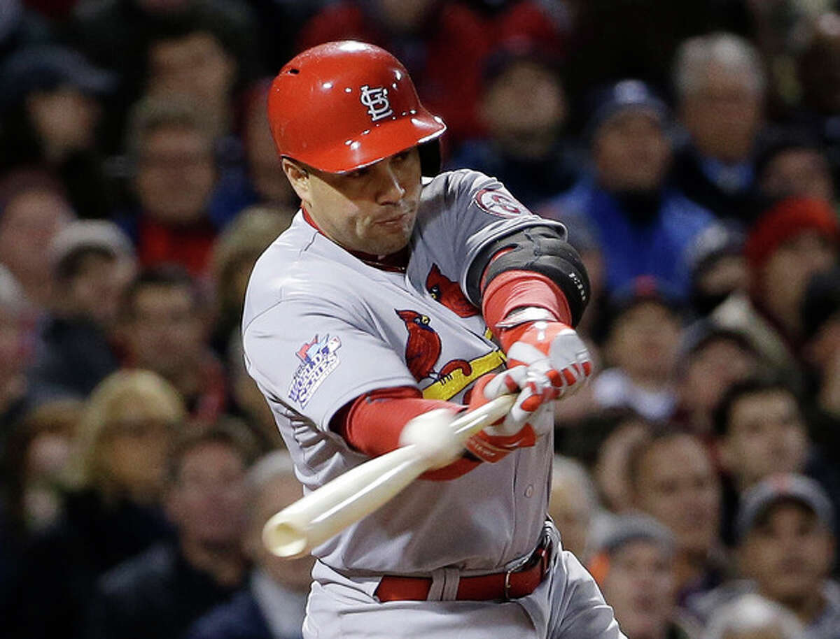 FILE - In this Oct. 24, 2013, file photo, St. Louis Cardinals' Carlos Beltran hits an RBI single during Game 2 of baseball's World Series against the Boston Red Sox in Boston. Two people familiar with the negotiations say outfielder Carlos Beltran and the New York Yankees have agreed to a $45 million, three-year contract. (AP Photo/David J. Phillip, File)