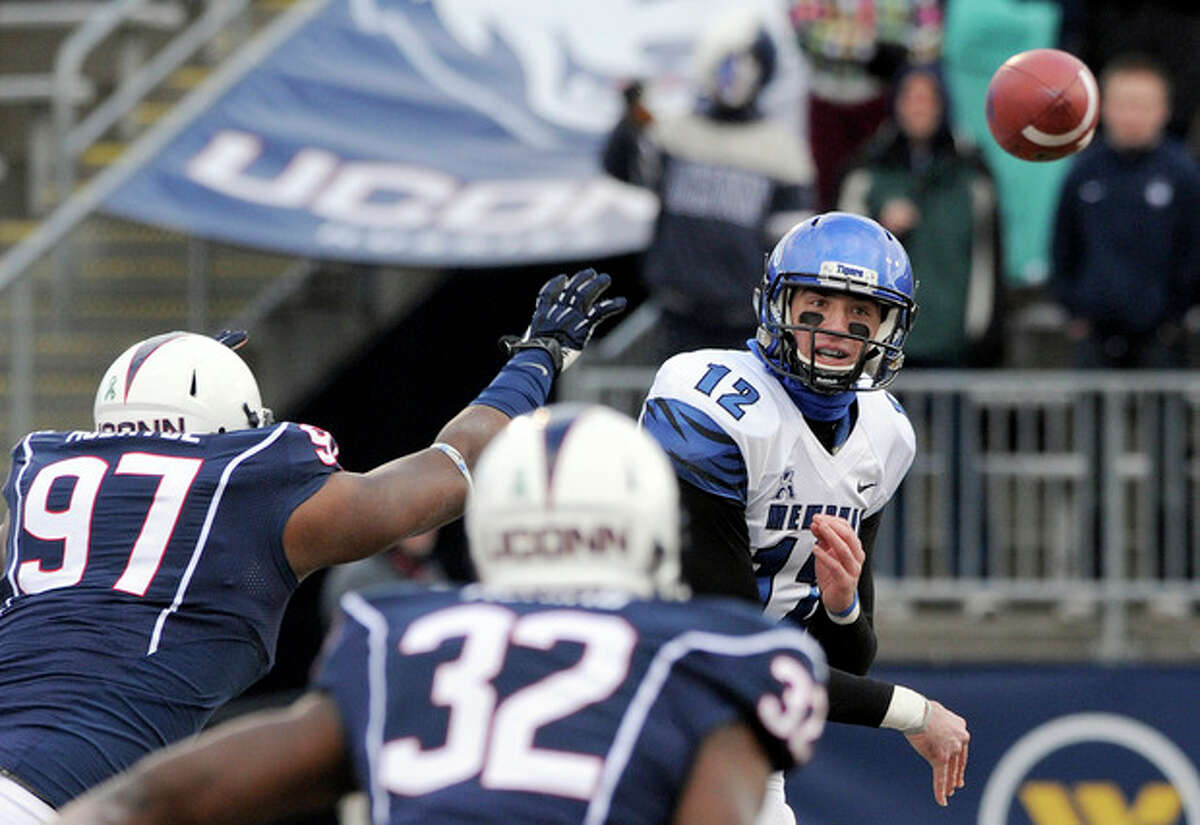 Memphis quarterback Paxton Lynch (12) passes while pressured by Connecticut defensive end B.J. McBryde (97) and Connecticut linebacker Jefferson Ashiru (32) during the first half of an NCAA college football game in East Hartford, Conn., on Saturday, Dec. 7, 2013. (AP Photo/Fred Beckham)