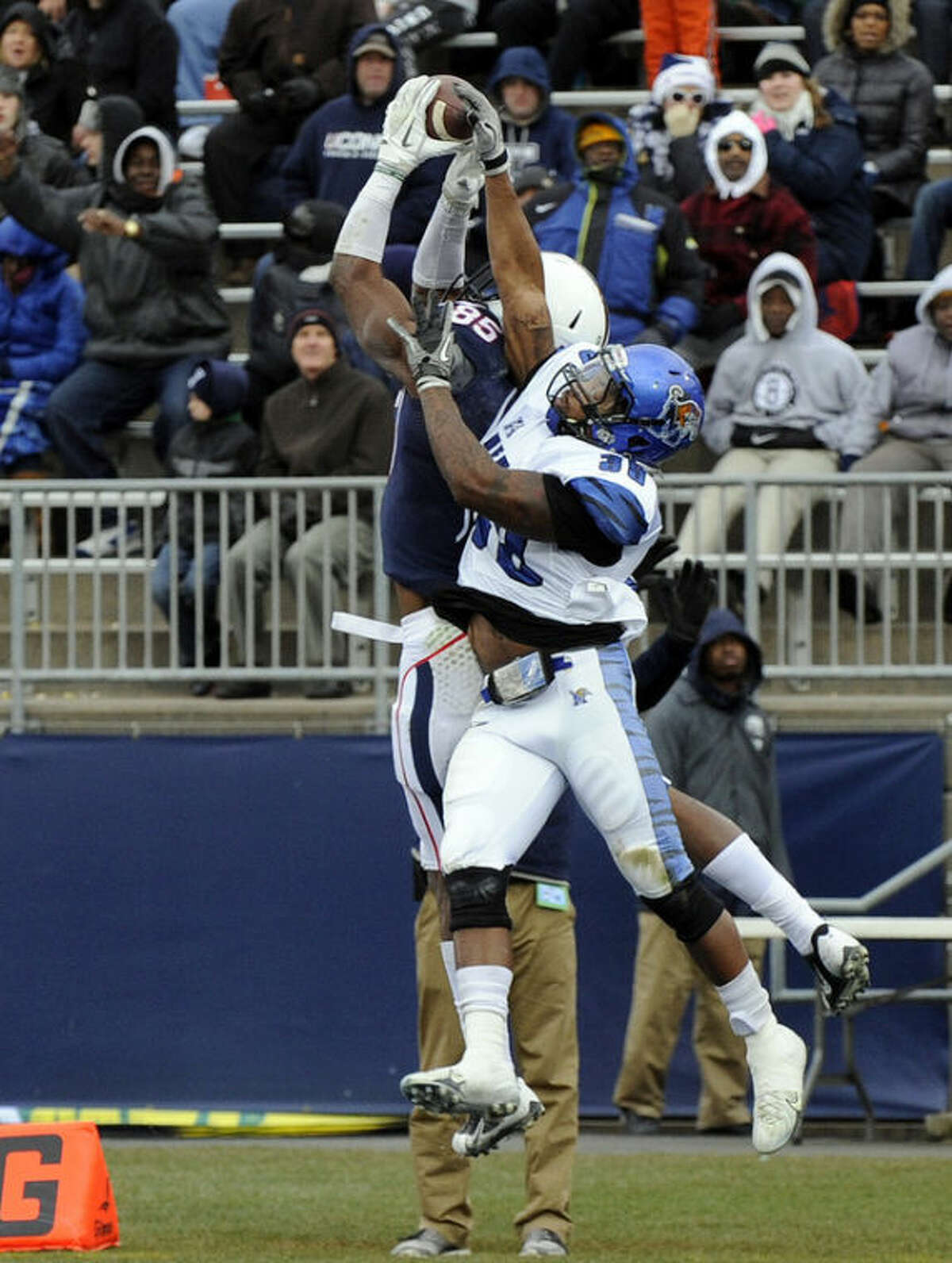Connecticut wide receiver Geremy Davis (85) catches a touchdown pass over Memphis defensive back Reggis Ball (39) during the first half of an NCAA college football game in East Hartford, Conn., on Saturday, Dec. 7, 2013. (AP Photo/Fred Beckham)