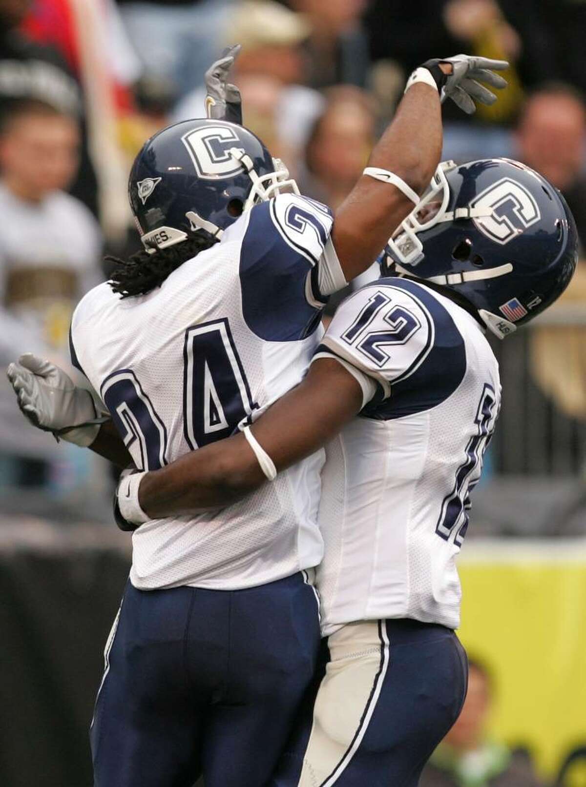 CHARLOTTE, NC - DECEMBER 29: Teammates Larry Taylor #24 and Marcus Easley #12 of the Connecticut Huskies celebrate after Taylors touchdown against the Wake Forest Demon Deacons at Bank of America Stadium on December 29, 2007 in Charlotte, North Carolina. (Photo by Streeter Lecka/Getty Images)