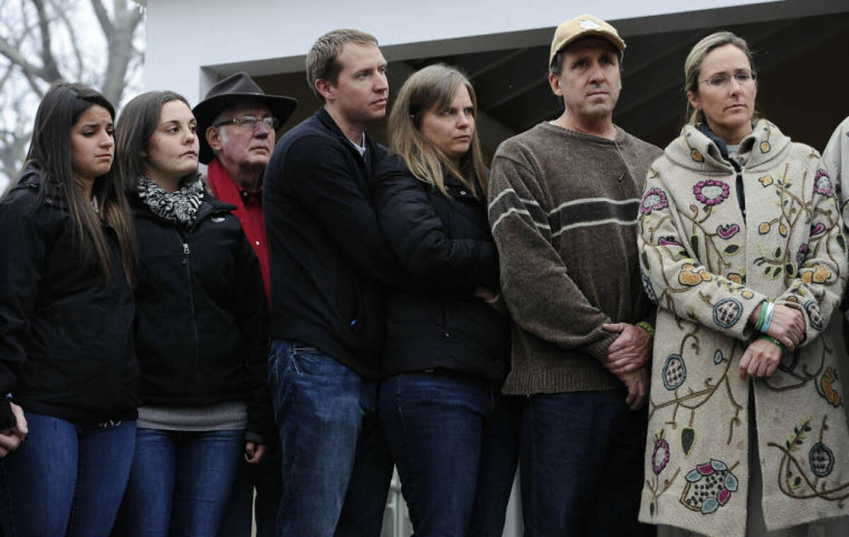 From the left, Carlee Soto, sister of Sandy Hook Elementary School shooting victim Victoria Soto, Erica Lafferty and George Hochsprung, daughter and husband of victim Dawn Hochsprung, Robbie and Alyssa Parker, parents of Emilie Parker, and Neil Heslin and Scarlett Lewis, parents of Jesse Lewis, stand with other family members as they address media, Monday, Dec. 9, 2013, in Newtown, Conn. Newtown is not hosting formal events to mark the anniversary Saturday. (AP Photo/Jessica Hill)
