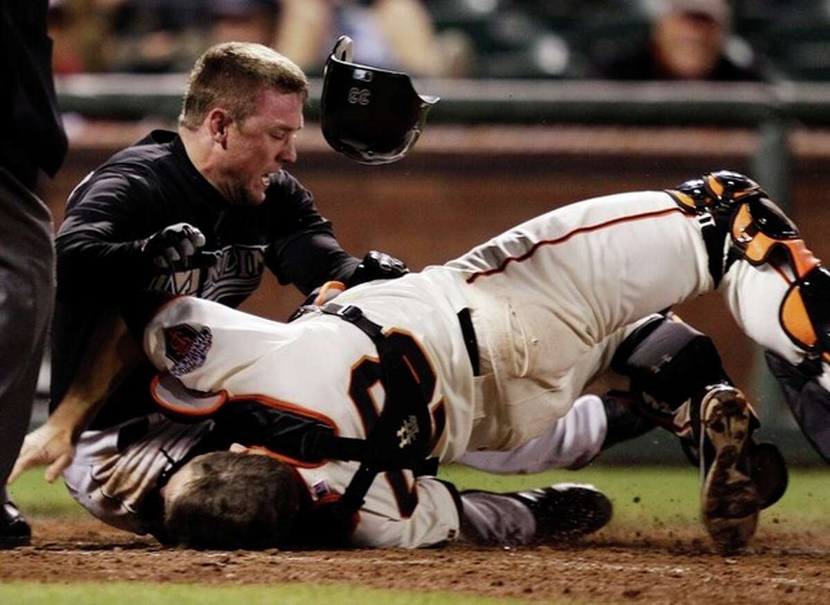 FILE - In this May 25, 2011, file photo, Florida Marlins' Scott Cousins, top, collides with San Francisco Giants catcher Buster Posey on a fly ball hit by Marlins' Emilio Bonifacio during the 12th inning of a baseball game in San Francisco. New York Mets general manager Sandy Alderson, chairman of the rules committee, announced Wednesday, Dec. 11, 2013, that Major League Baseball plans to eliminate home plate collisions. He said player health and increased awareness of concussions were behind the decision. (AP Photo/Marcio Jose Sanchez, File)