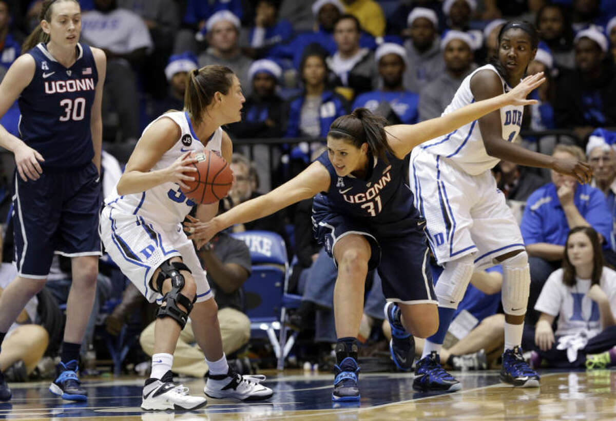 Connecticut's Stefanie Dolson (31) reaches for the ball against Duke's Haley Peters, left, and Elizabeth Williams, right, during the second half of an NCAA college basketball game in Durham, N.C., Tuesday, Dec. 17, 2013. Connecticut won 83-61.(AP Photo/Gerry Broome)