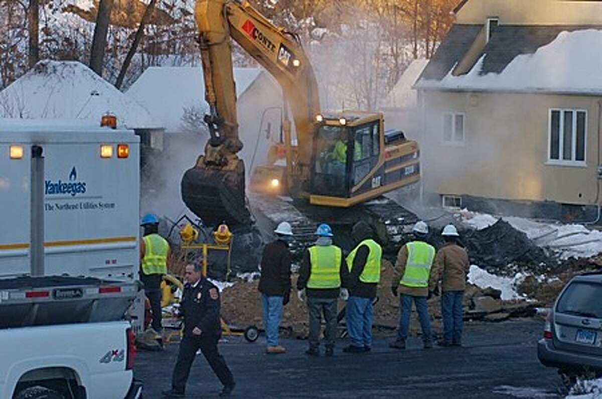 A Yankee Gas crew looks over the demolition of the home on Ohio Ave Ext. which exploded last night after gas leaked into the basement of the home. One resident was injured and two excaped unharmed. Hour photo / Erik Trautmann