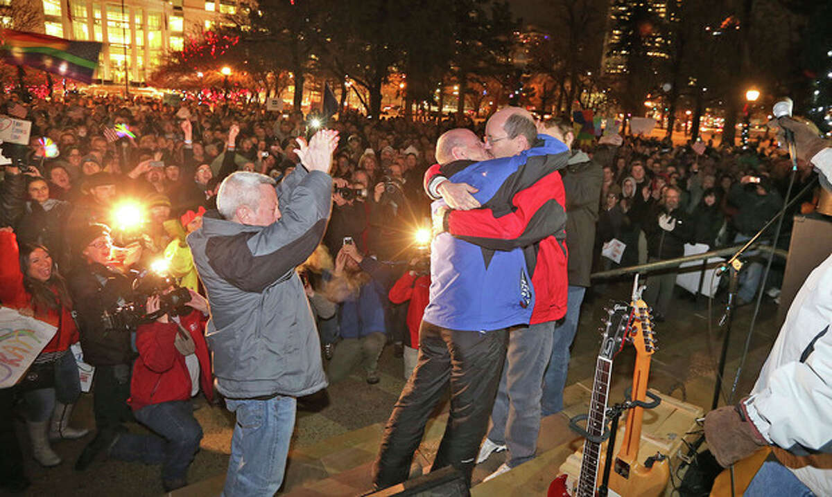 Dan Trujillo, left, and Clyde Peck get married as about 1,500 people gather to show support of marriage equality after a federal judge declined to stay his ruling that legalized same-sex marriage in Utah, at Washington Square, just outside of the Salt Lake City and County Building Monday, Dec. 23, 2013, in Salt Lake City. (AP Photo/The Deseret News, Tom Smart)