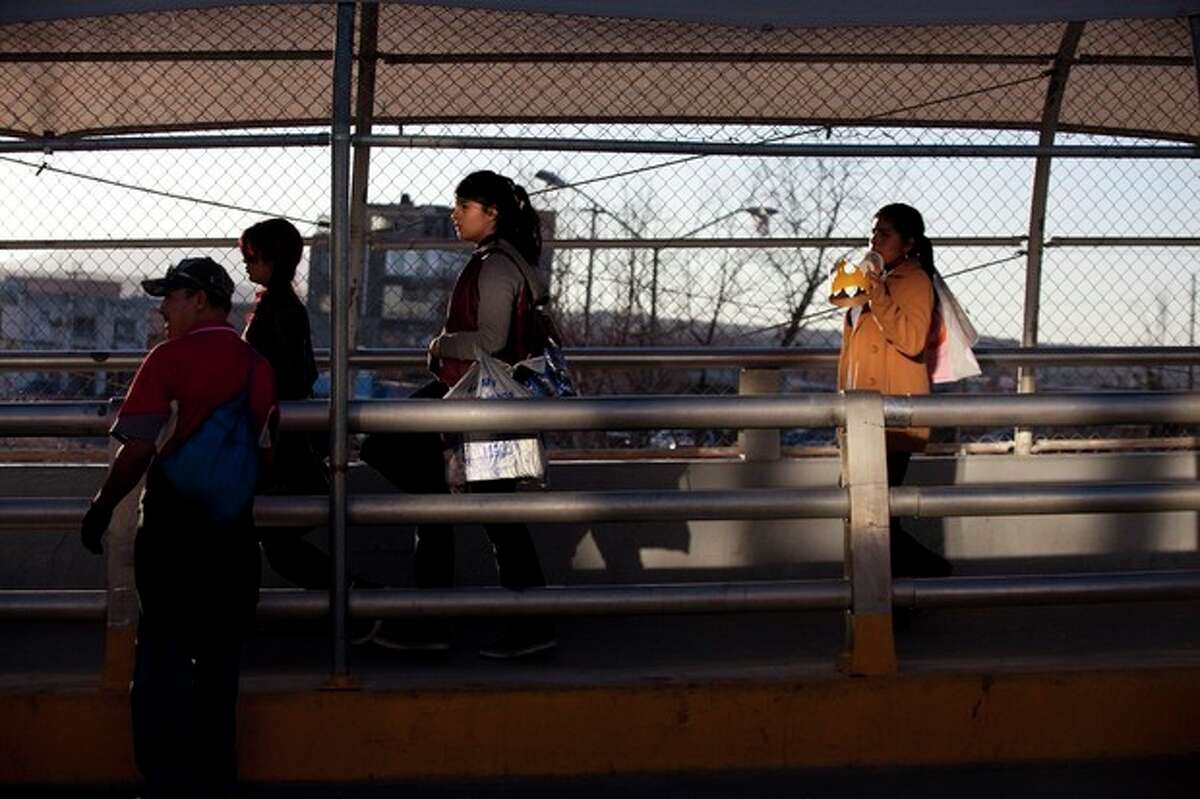 In this Thursday, Dec. 26, 2013 photo, people with goods from the Unites States in hand cross back into Mexico at The Paso del Norte Bridge between El Paso, Texas and Ciudad Juarez. Twenty years ago, the North American Free Trade Agreement went into effect, at supermarkets, shoppers are now familiar with everything from cranberries to chai and lemons (as opposed to the Mexican lime) that few had tasted before the treaty tore down trade barriers and tariffs between Mexico, Canada and the United States. . (AP Photo/Ivan Pierre Aguirre)