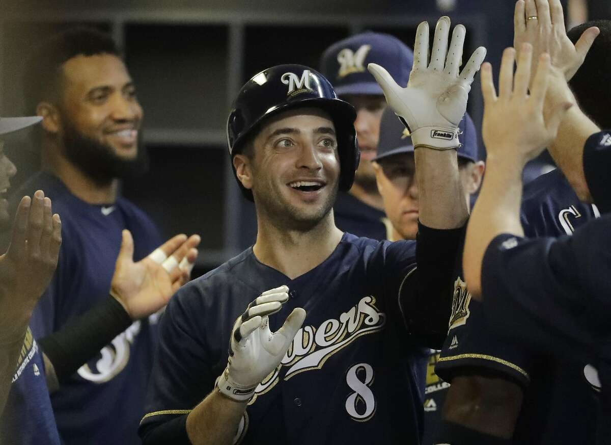 Milwaukee Brewers' Ryan Braun is congratulated in the dugout after hitting a single during the sixth inning of a baseball game against the Oakland Athletics Tuesday, June 7, 2016, in Milwaukee. The hit was Braun's 1,500 career hit. (AP Photo/Morry Gash)