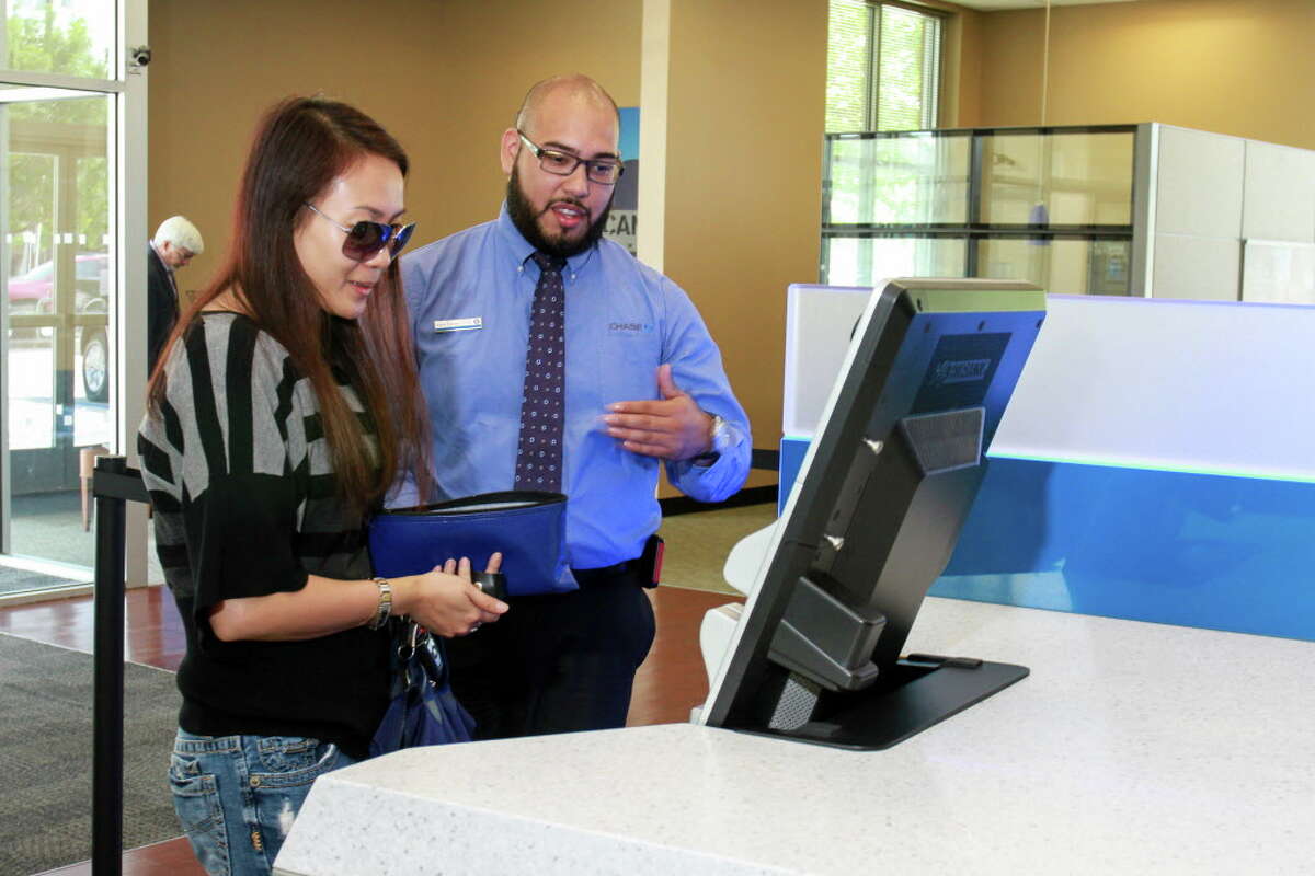 Customer Jenny Ngo gets some help from bank teller Mark Flores using one of the new generation ATMs in the Chase lobby at the Washington and Studemont branch. (For the Chronicle/Gary Fountain, May 13, 2016)
