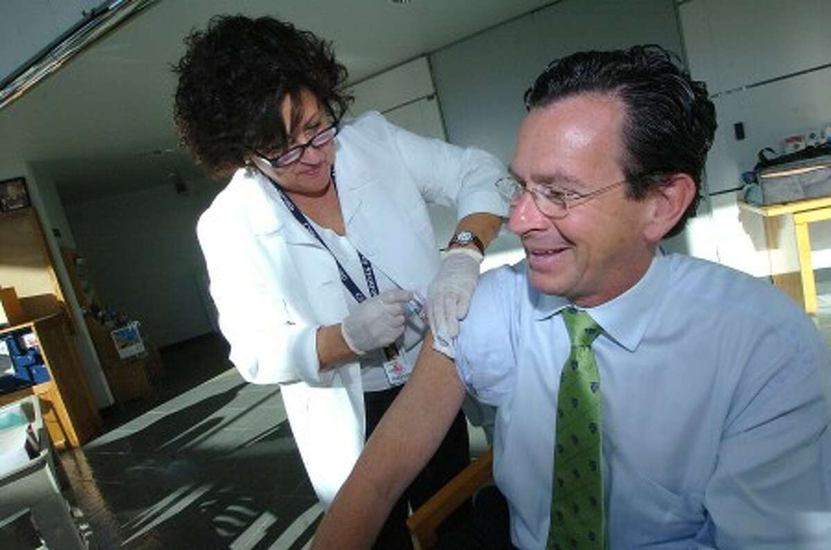 Photo/Alex von Kleydorff. Stamford health System R.N. Lynn Galgano gets Mayor Malloy immunized with a flu vacine at the Government center.