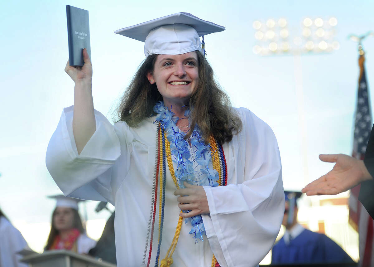 Graduate Wilhelmina Stuhlman shows her diploma to her family as she crosses the stage during the Fairfield Ludlowe High School graduation in Fairfield, Conn. on Thursday, June 16, 2016.