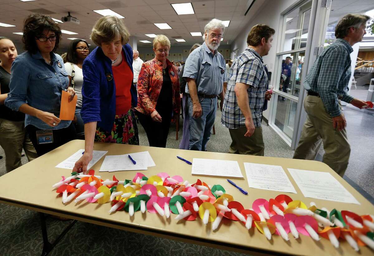 People pick up candles as they file past them on a table during a vigil for the victims of the Pulse nightclub shootings, at the University of Houston-Clear Lake, Thursday, June 16, 2016, in Clear Lake.