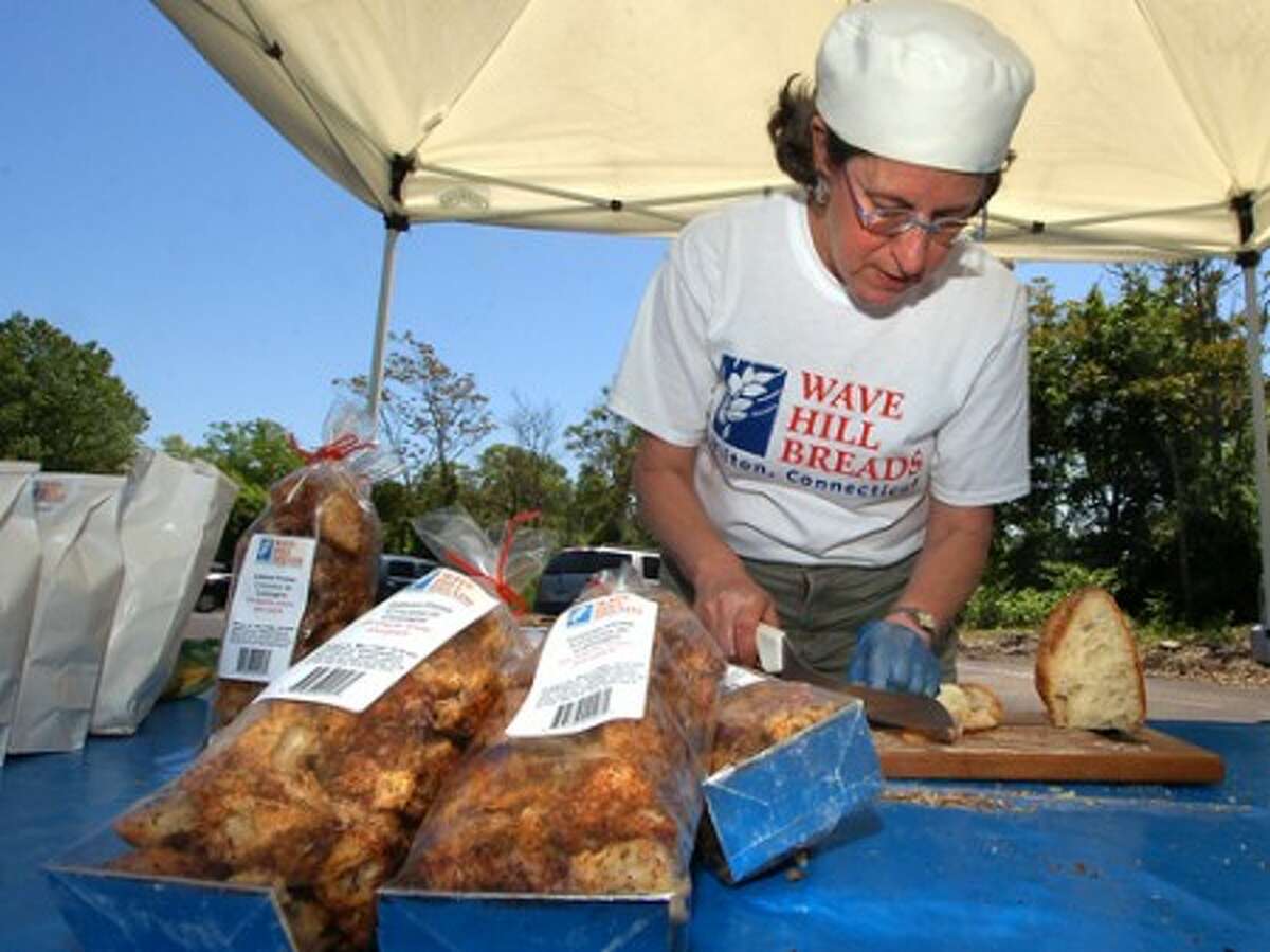 Photo/Alex von Kleydorff. Margaret Sapir, co owner of Wave Hill Breads, cuts up some samples of their rustic bread at the Westport Farmers Market.