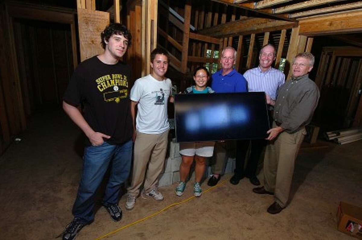 Photo/Alex von Kleydorff. Energy efficient vollunteer builders L-R, Daniel Chalons-Browne, Reed Dempsey, Alison Pogust, Tim Seamans, Jim Lyle and Ron French. Present a solar panel, part of the energy saving devices built into a Bridgeport home.