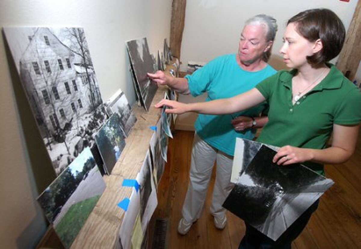 Photo/Alex von Kleydorff. l-r Wilton Historical Society Archivist Scotty Taylor and Curator Andrea Wulffleff prepare the Route 7 exhibit in one of the galleries.