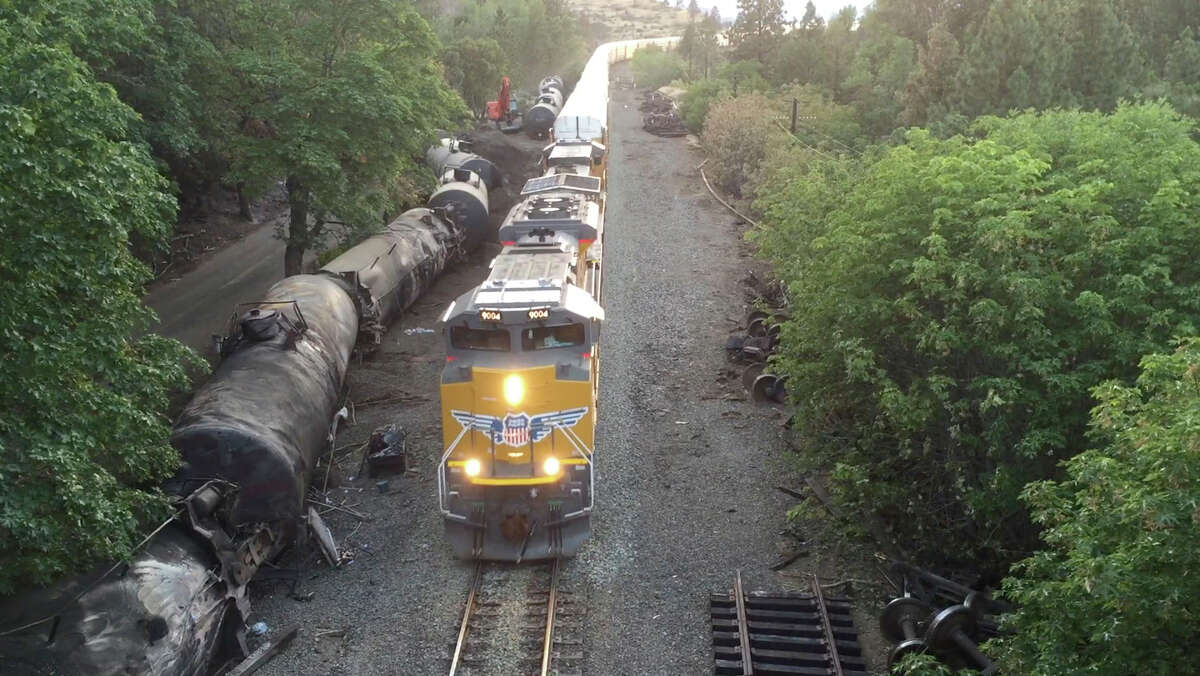 FILE - This June 6, 2016, file photo taken from a drone, shows crumpled oil tankers lying beside the railroad tracks after a fiery train derailment on June 3, 2016, that prompted evacuations from the tiny Columbia River Gorge town about 70 miles east of Portland in Mosier, Ore. The fiery derailment of an oil train in Oregon's Columbia River Gorge has state transportation officials asking for a halt to the massive trains because of concerns their heavier weight could be putting extra strain on a certain type of bolt that fastens the rails to the tracks. The Oregon Department of Transportation discussed its concerns about the safety of the so-called ?“lag bolts?” in a presentation Thursday, June 16, 2016. (Brent Foster via AP, File) MANDATORY CREDIT
