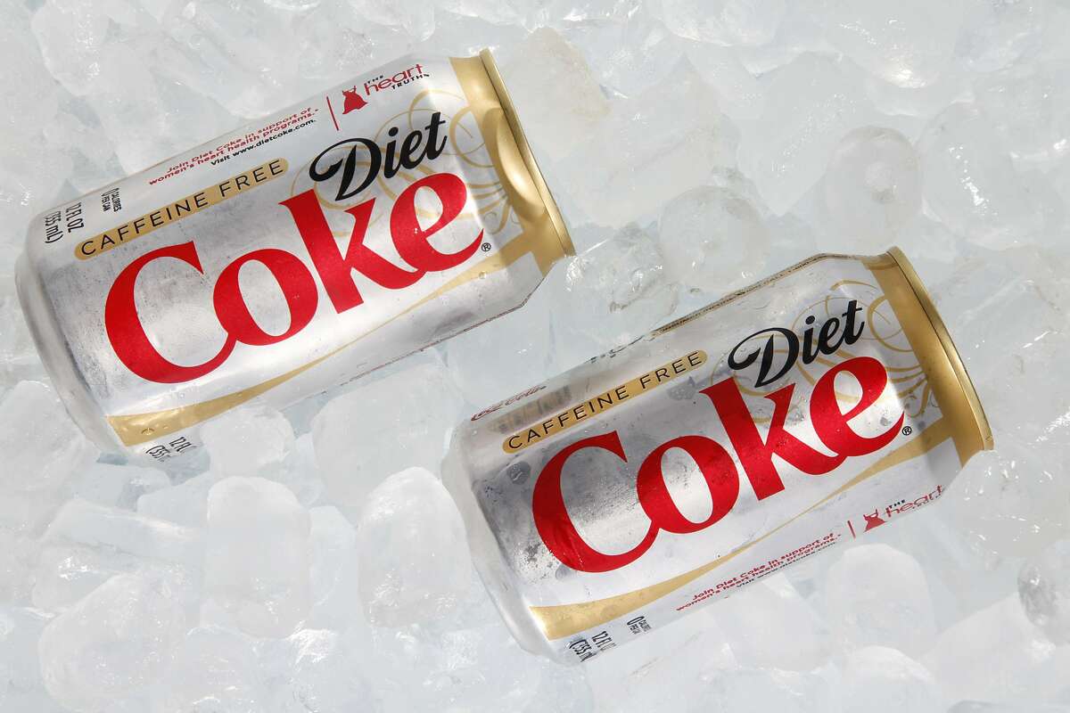 FILE - This Monday, Oct. 15, 2012 file photo shows two cans of Caffeine Free Diet Coke on ice in Surfside, Fla. During a conference call with analysts Tuesday, Oct. 15, 2013, a Coca-Cola executive noted that Diet Coke was "under a bit of pressure" because of people's concerns over its ingredients, alluding to the growing wariness of artificial sweeteners in recent years. Soda has been under fire from health advocates for several years now, and Americans have been cutting back on sugary fizz for some time. But in a somewhat newer development, diet sodas are falling at a faster rate than regular sodas, according to Beverage Digest, an industry tracker. (AP Photo/Wilfredo Lee, File)
