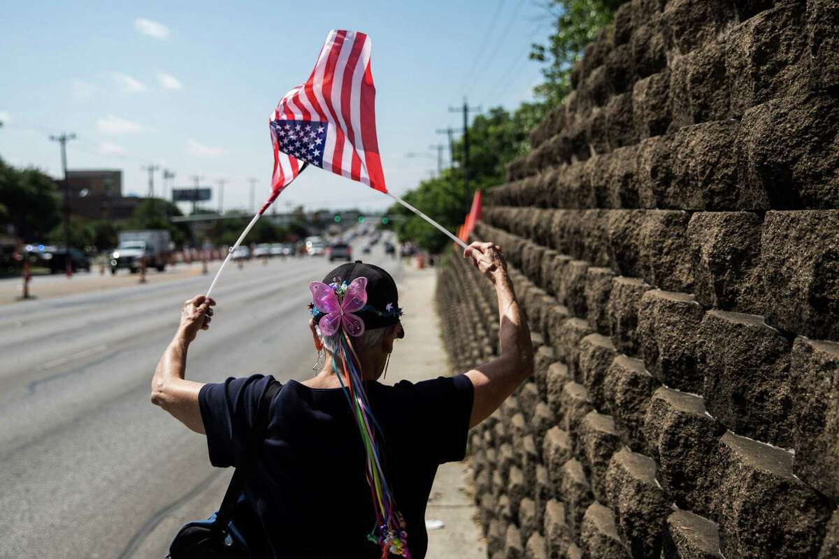 San Antonio, Texas -- June 17, 2016 -- Mary Elizabeth Gephart Bruton waved flags as she walked to gathering of people supporting Republican presidential candidate Donald Trump's visit to San Antonio near his private fundraiser at Oak Hills Country Club. Ray Whitehouse/for the San Antonio Express-News