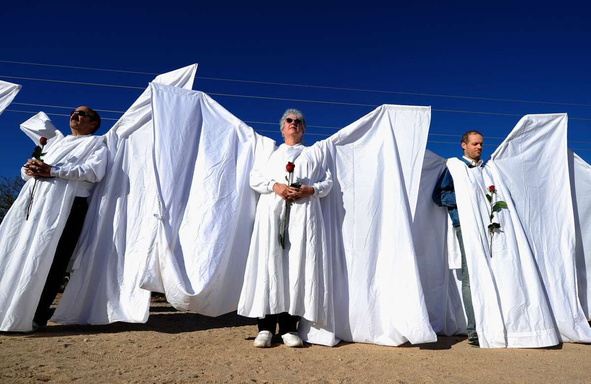 A group of staff and volunteers from Orlando Shakespeare Theater as well as ​the​ Orlando arts community work together to build "Angel Wings" to block Westboro Baptist Church members protesting the funerals of the Orlando shooting victims. When finished, they will look like this. Pictured: Mourners dressed as angels stand across the street from St. Elizabeth Ann Seton church where the funeral service for US District Court Judge John Roll is being held on January 14, 2011 in Tucson, Arizona. 