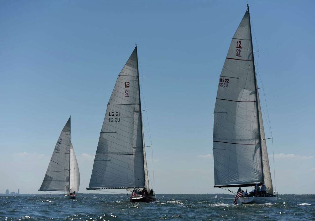 The Bank of America sailboat manned by disabled veterans, center, competes with two Bridgewater Associates boats in the Sail to Prevail Belle Haven Challenge Cup in the waters of the Long Island Sound off the shore of Belle Haven Club in Greenwich, Conn. Sunday, June 19, 2016. Twelve disabled veterans from New York and Connecticut served as active crew members on one of the three vintage America's Cup yachts that participated in the competitive sailing races on the Sound. Now in its 18th year, the Challenge Cup allowed the disabled vets to join in competitive camaraderie with Bank of America employees on their boat while competing against two Bridgewater Associates boats.