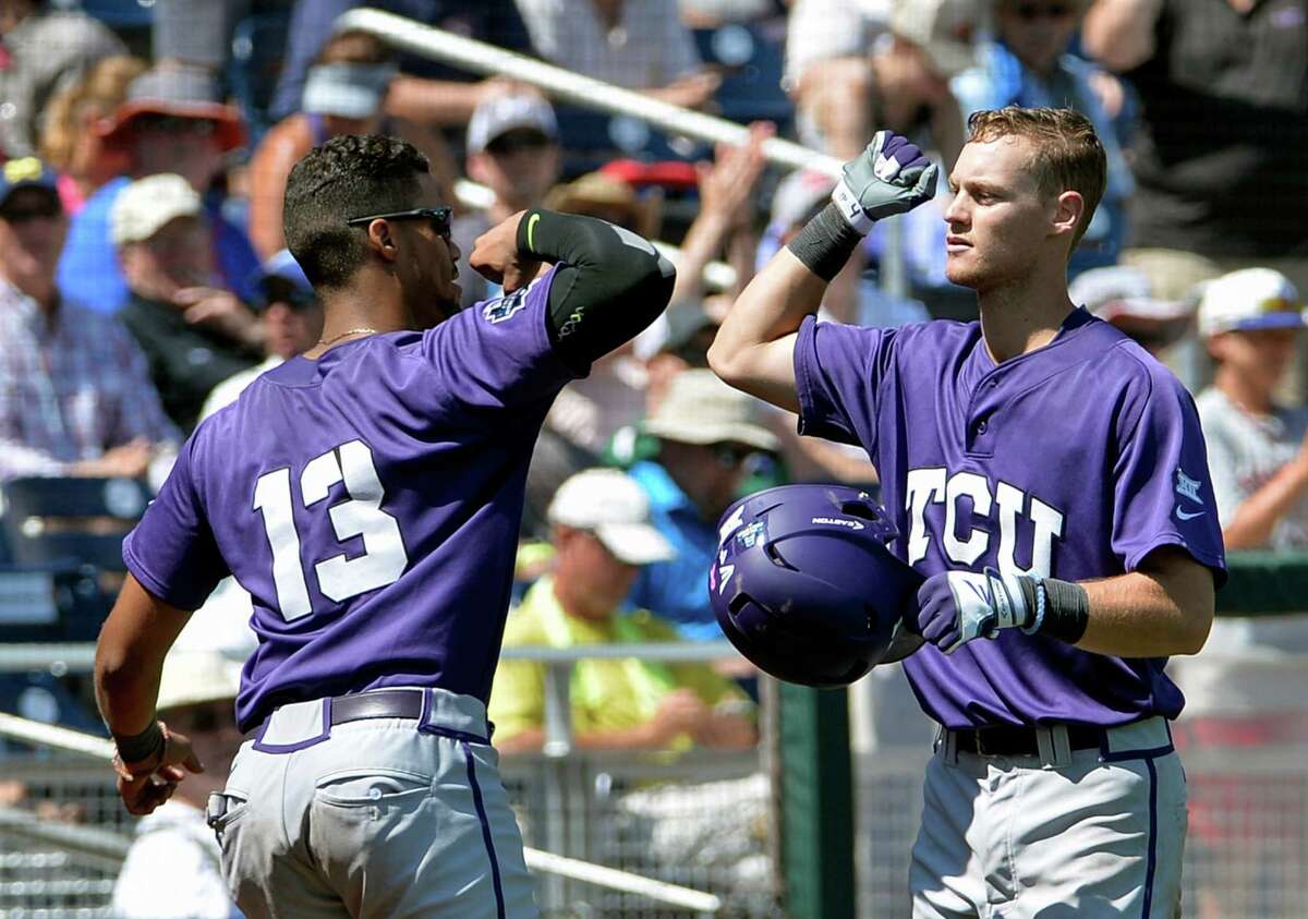 TCU Cam Warner, right, is congratulated by teammate Michael Landestoy (13) after scoring a solo home run during the fifth inning of an NCAA men's College World Series baseball game against Texas Tech in Omaha, Neb., Sunday, June 19, 2016. (AP Photo/Mike Theiler)