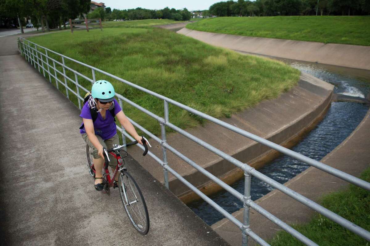 A bicycle rider travels along Brays Bayou on June 20, 2016.