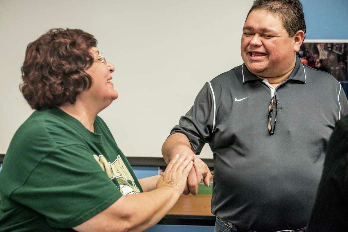 Josie Scales, a member of the Harlandale PTA Council, left, shakes the hand of Raul Navaira, brother of the late Tejano star Emilio Navaira, on June 1, when the Harlandale ISD board of trustees meeting took no action on a proposal to rename Vestal Elementary after the bandleader. The board again postponed a decision Monday evening.