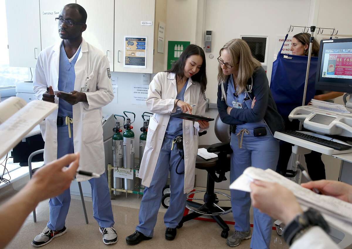 Denise Chang, MD (middle) uses the software of Project Emerge on a tablet with Abdul Kouanda (left) and Laura Schoenher, MD (right) as the staff make patient rounds in an intensive care unit at UCSF hospital on Wednesday, June 15, 2016 in San Francisco, Calif.. UCSF and Johns Hopkins University School of Medicine are testing software they hope will improve intensive care.