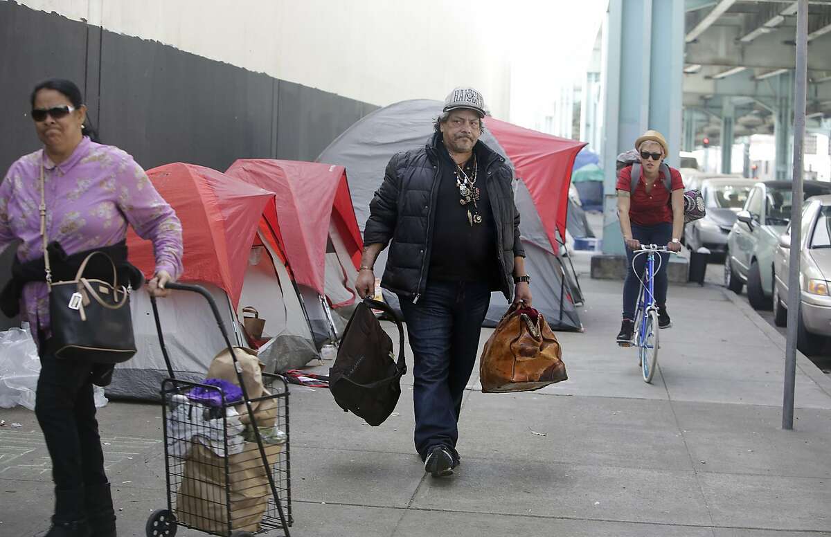 Papa Smirf (center) carries some of his belongings down the 13th Street as he prepares to move from his tent on 13th Street to Pier 80 with help from the San Francisco Homeless Outreach Team on Thursday, February 25, 2016 in San Francisco, California.