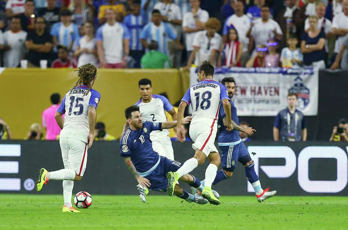 Argentina midfielder Lionel Messi (10) falls after contact with United States forward Chris Wondolowski (18), setting up a penalty kick where Messi scored a goal during the first half of a COPA America semi-final game at NRG Stadium, Tuesday, June 21, 2016, in Houston.