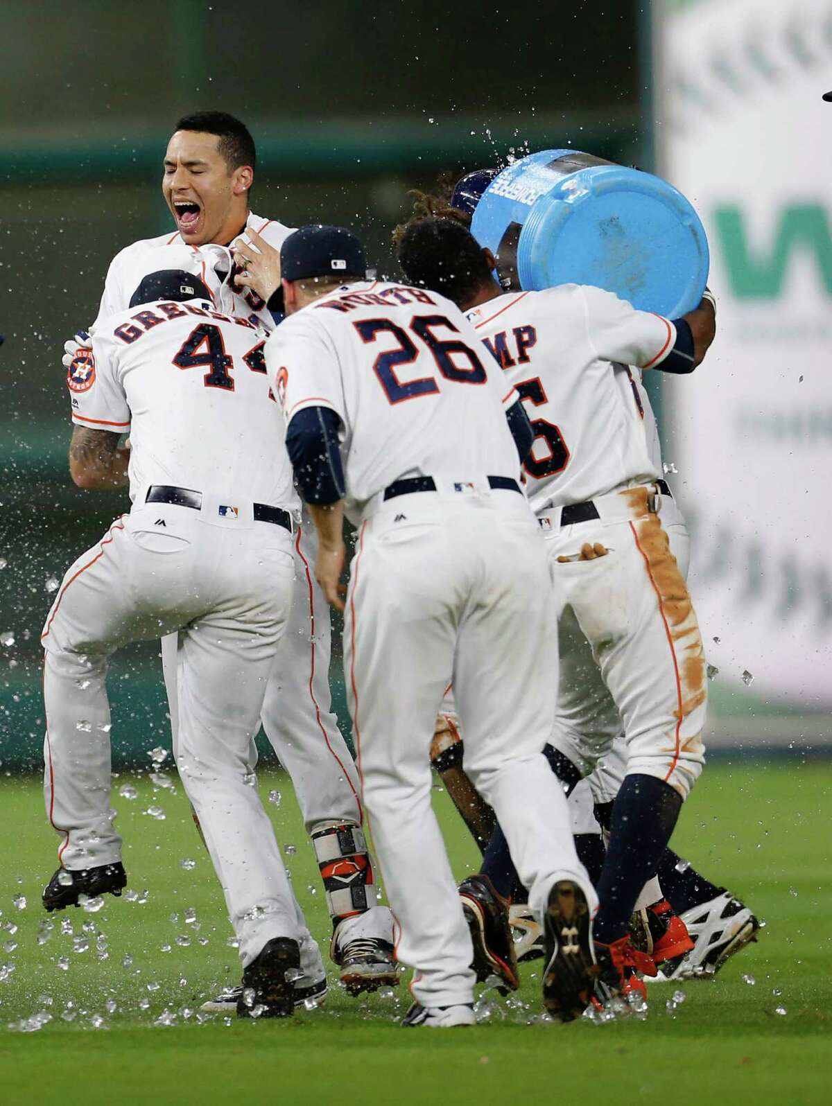 Shortstop Carlos Correa, rear, receives a celebratory water-cooler bath from his teammates after hitting a two-run, walkoff single to propel the Astros to a 3-2 win over the Angels on Tuesday at Minute Maid Park.