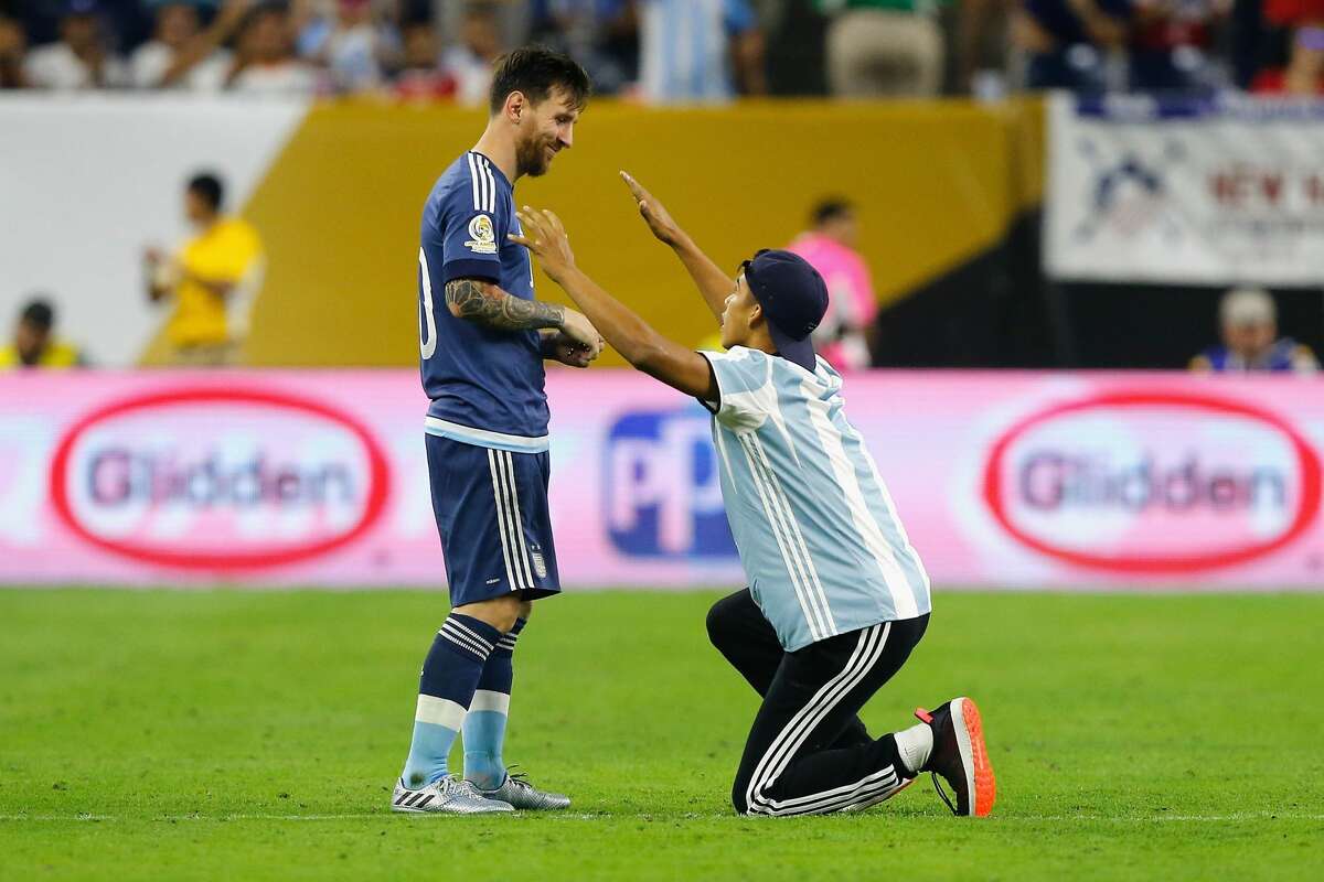 HOUSTON, TX - JUNE 21: Lionel Messi #10 of Argentina interacts with a fan who ran onto the field prior to the start of the second half during a 2016 Copa America Centenario Semifinal match between Argentina and the United States at NRG Stadium on June 21, 2016 in Houston, Texas. (Photo by Bob Levey/Getty Images)