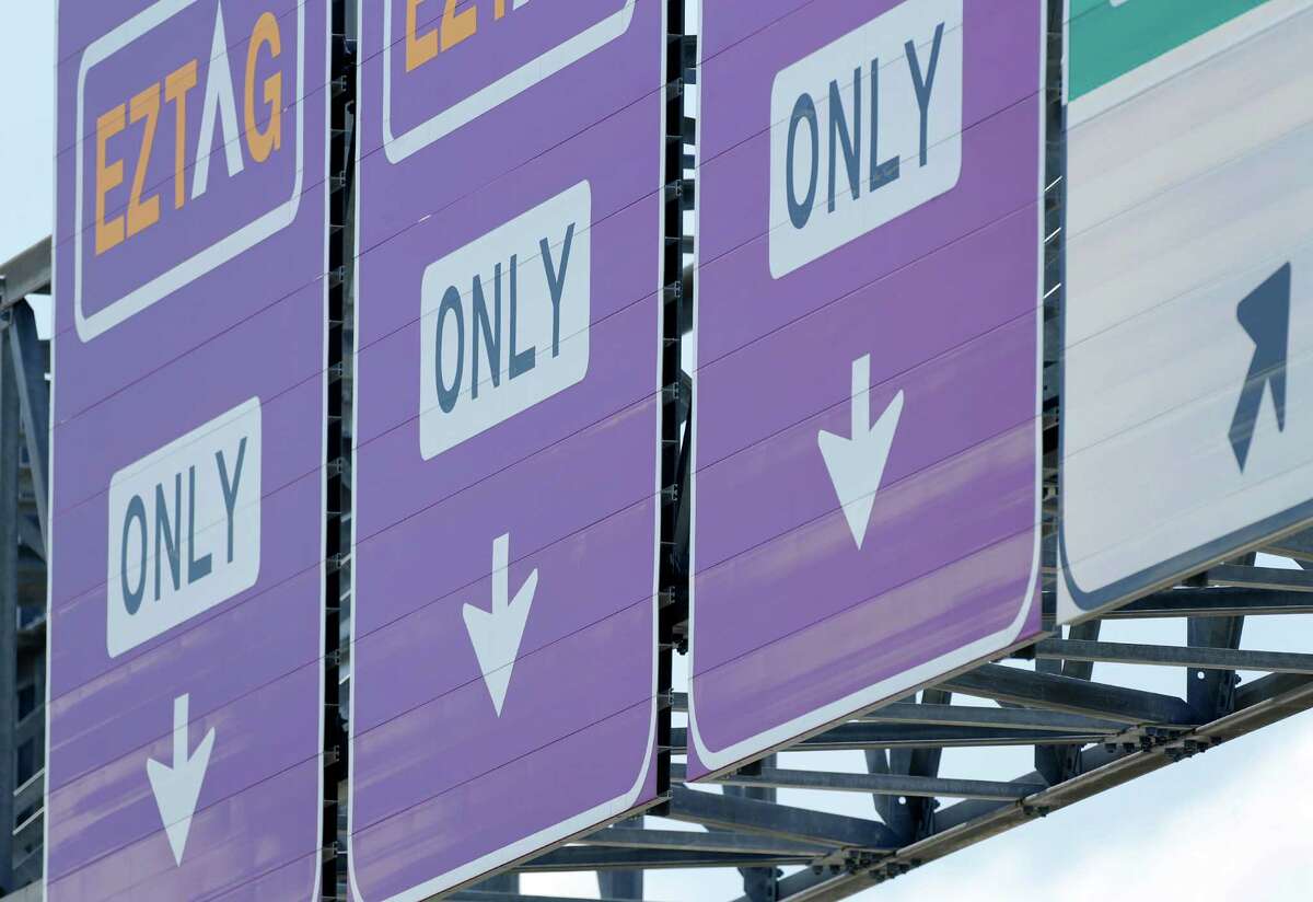 Signs point the way to EZ TAG lanes on the Sam Houston Tollway on June 16.