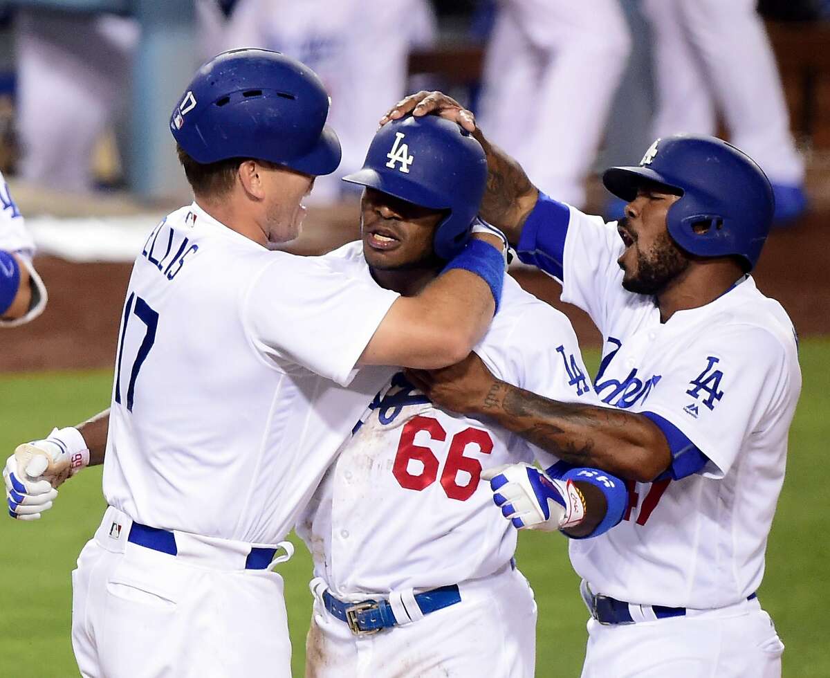 LOS ANGELES, CA - JUNE 22: Yasiel Puig #66 of the Los Angeles Dodgers celebrates his inside the park homerun with A.J. Ellis #17 and Howie Kendrick #47 to win the game 4-3 over the Washington Nationals during the ninth inning at Dodger Stadium on June 22, 2016 in Los Angeles, California. (Photo by Harry How/Getty Images)