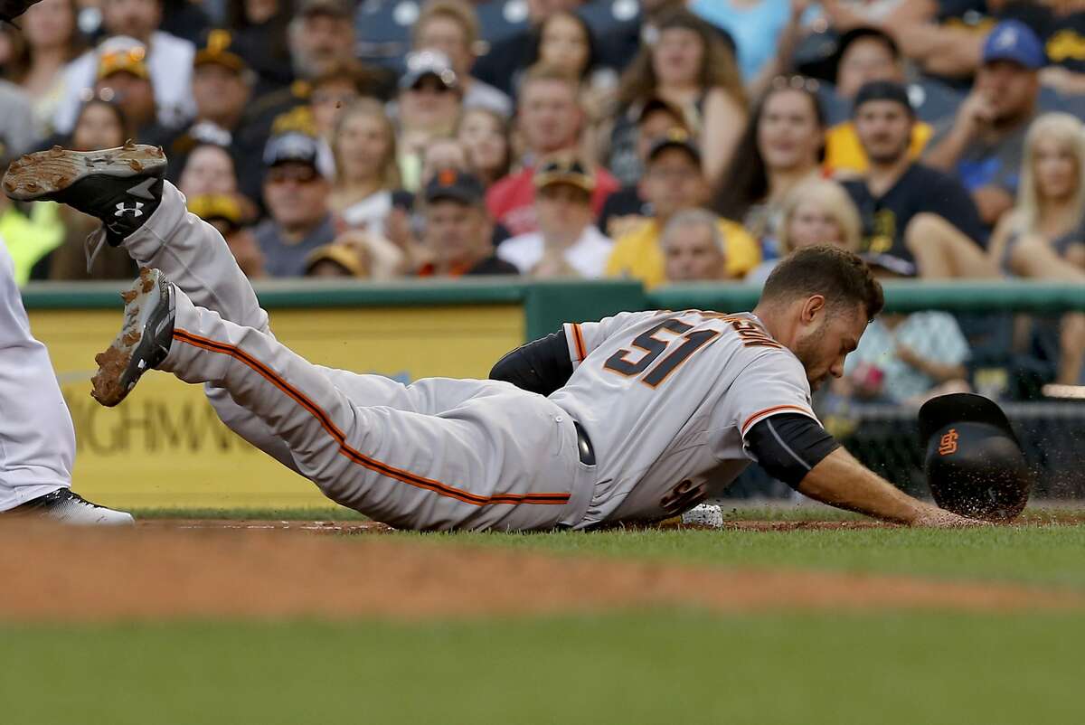 San Francisco Giants' Mac Williamson (51) loses his helmet as he dives safely back to first after Pittsburgh Pirates first baseman John Jaso caight a line drive by Brandon Crawford during the second inning of a baseball game, Wednesday, June 22, 2016, in Pittsburgh. (AP Photo/Keith Srakocic)