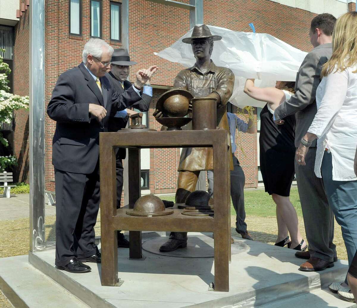 Hatter's Monument is unveiled in a ceremony outside City Hall in Danbury on Monday.