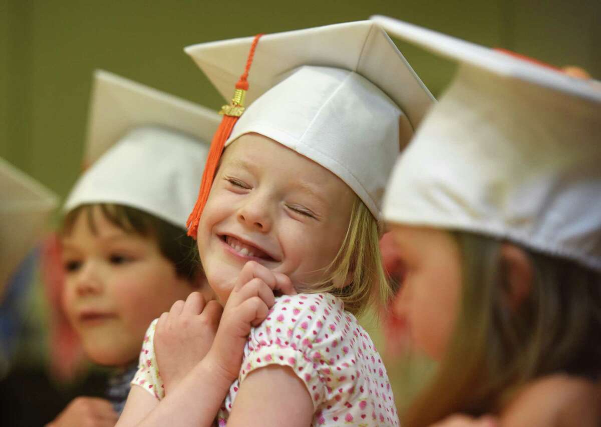 Rose McLean hugs herself as part of a dance routine during the Fours Moving Up Ceremony at the YWCA's Steven & Alexandra Cohen Preschool Center in Greenwich, Conn. Thursday, June 23, 2016. 17 students wore graduation caps and performed song and dance routines in celebration for moving up to the next level at the YWCA.