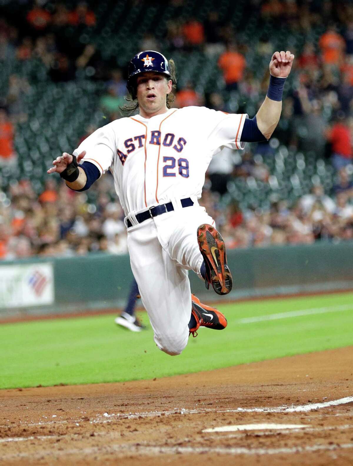Astros’ Colby Rasmus slides into home plate to score a run during the first inning against the Los Angeles Angels on June 20, 2016, in Houston.