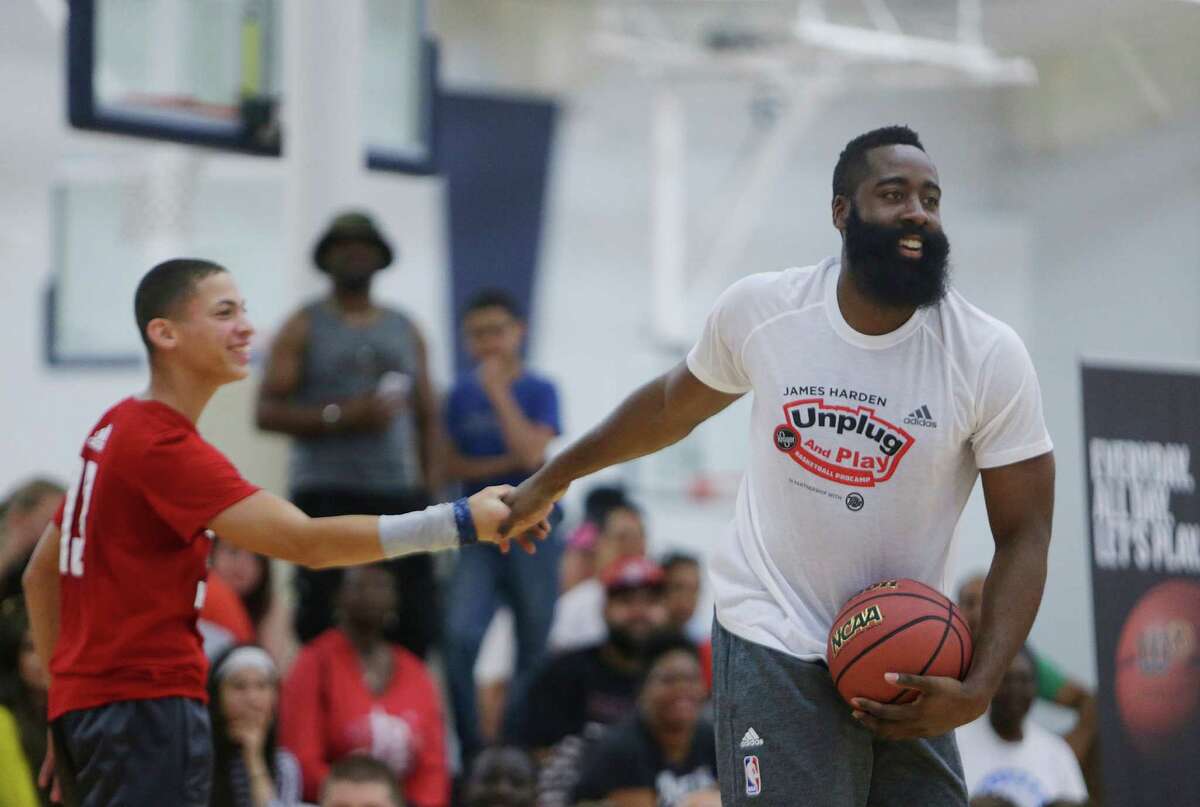 James Harden congratulates a camper during an elimination game at the James Harden Basketball ProCamp,Thursday, June 23, 2016, in Houston.