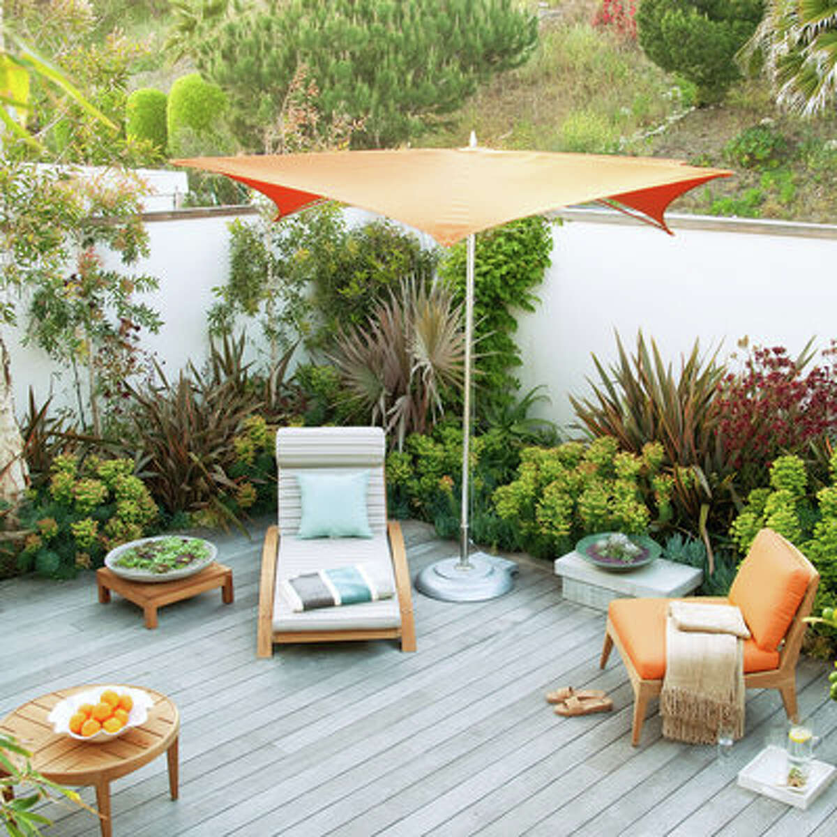 Staycation Bring out the striped cushions and colorful umbrellas, and get transported to a dream vacation spot right in your backyard. The deck is made of sustainable ipe wood that has weathered to a soft gray. Drought-tolerant plants need only yearly trimming and occasional watering—which leaves plenty of time to kick back on a lounge chair and bask in the sun.