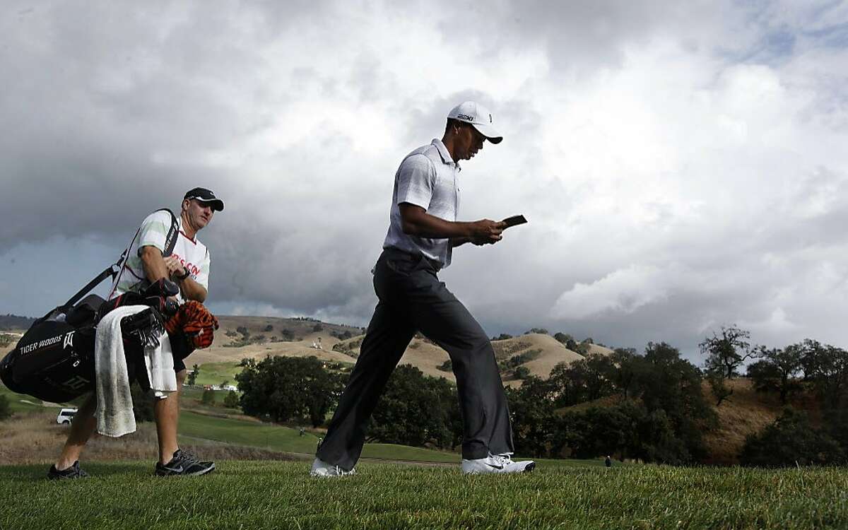 Tiger Woods, followed by his caddie Joe LaCava as they walk from the 6th tee, as the Pro-Am gets underway at the Frys.com Open at the CordeValle Golf Club in San Martin, Ca. on Wednesday October 5, 2011.