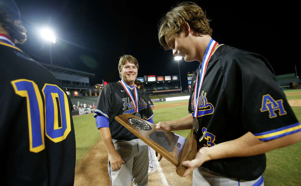 Alamo Heights’ Morgan Dawley looks at the runner-up trophy with Jered Aldaz (22) and Michael Kelleher (10) after their team fell to Grapevine 9-2 during the UIL state baseball 5A championship in Round Rock on June 10, 2016.