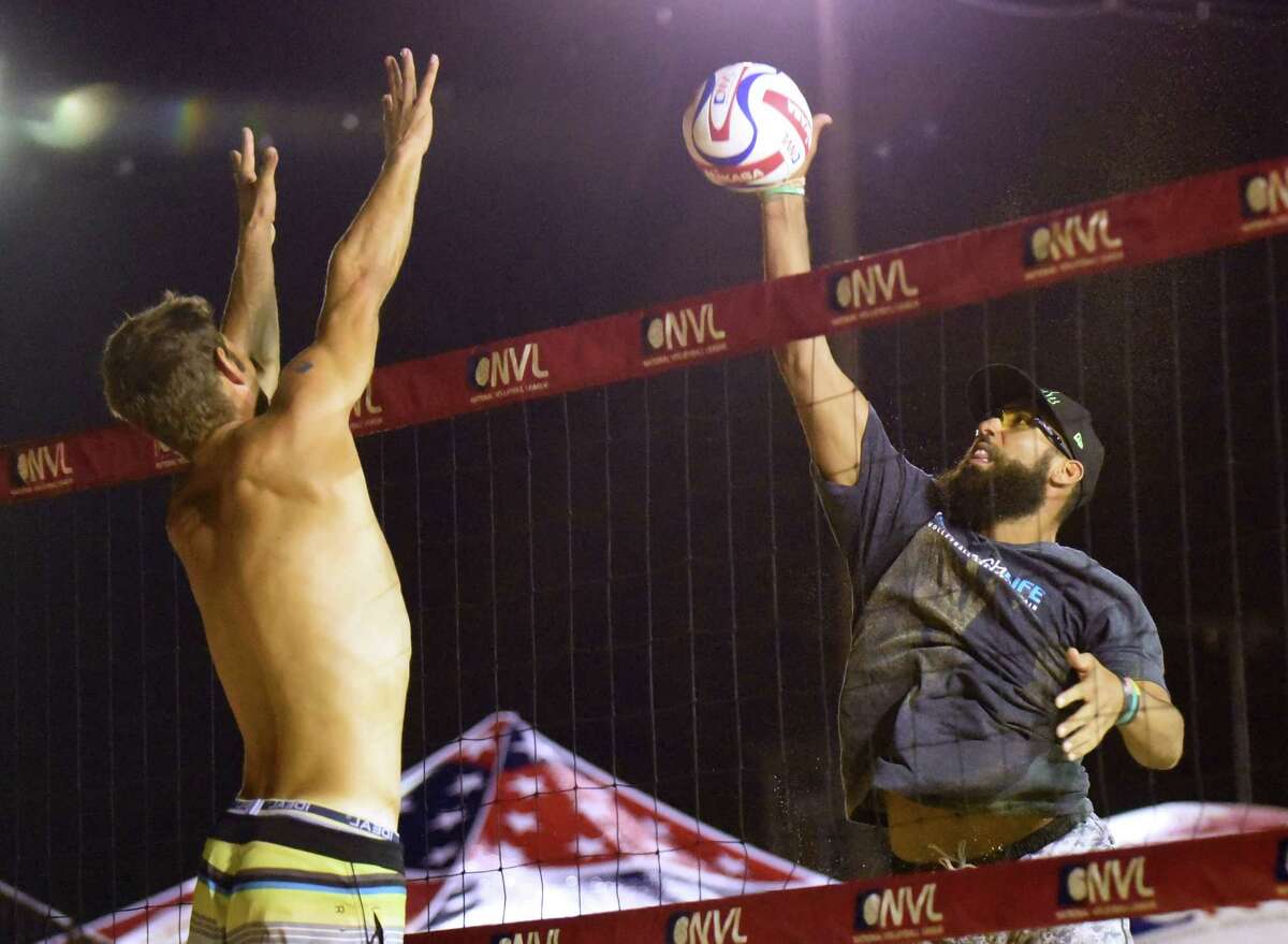 Dave Palm tips the ball past Piotr Marciniak during the men's finals of the Texas Championships of the National Volleyball League at Sideliners Grill on Saturday, June 25, 2016.